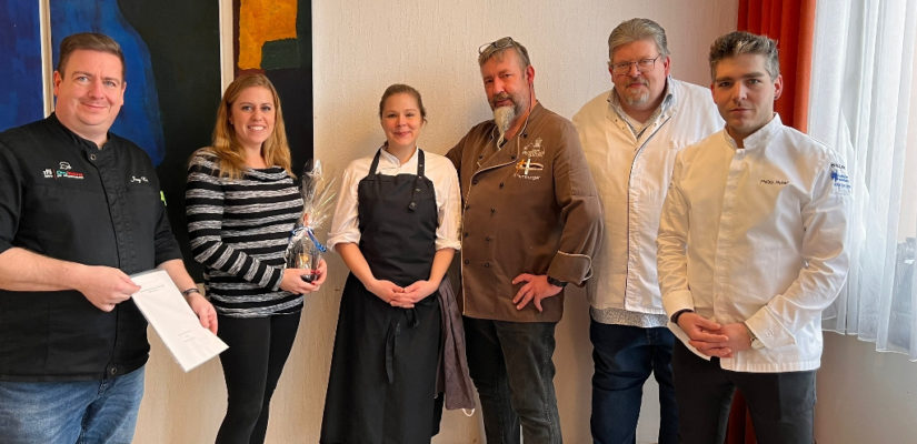 Gruppenbild. Ehrung einer Schülerin, die Ausbildung erfolgreich bestanden hat.